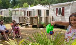 Famille devant Mobil home au camping Les Pierres Couchées